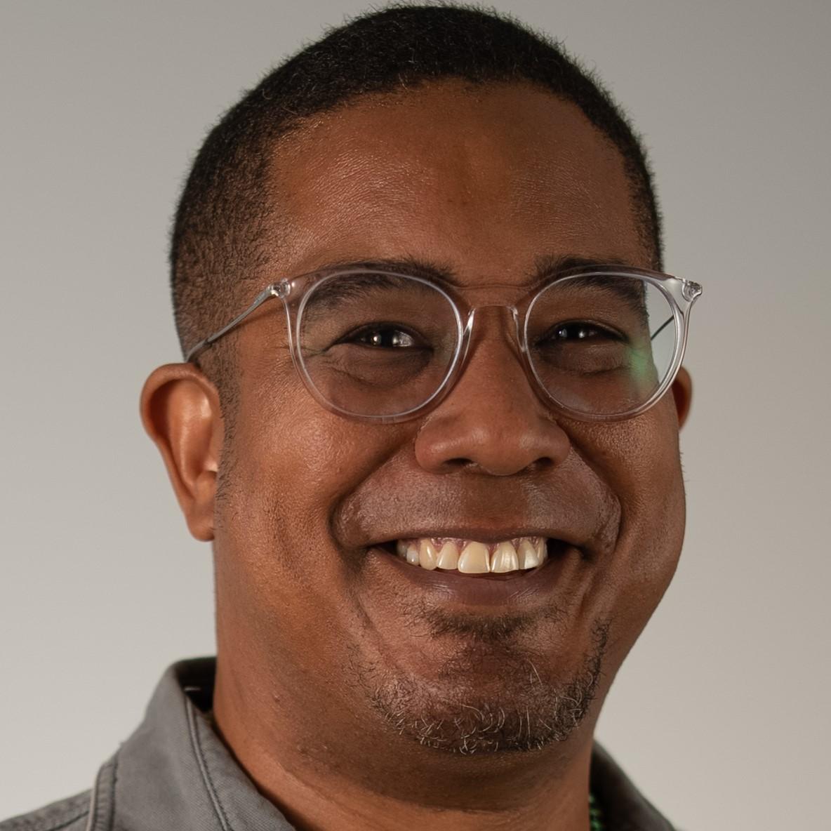 Londell Jackson headshot: male with shaved/short haircut and clear rimmed glasses.