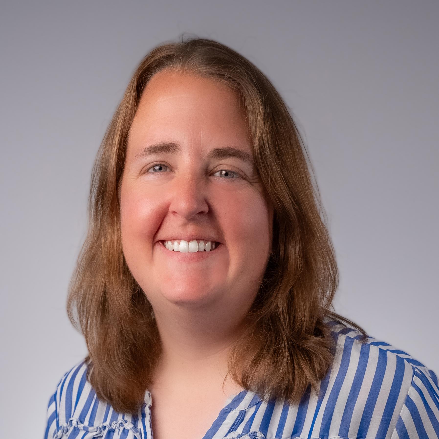 Katherine Keegan headshot: white female with long blonde hair in a purple shirt and scarf