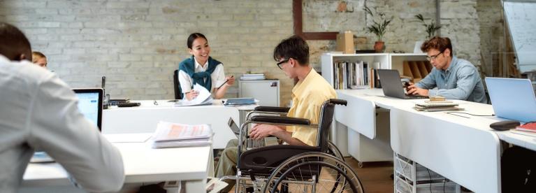 Employee in a wheelchair working in an office setting.