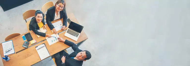 Group of diverse professionals in a meeting and exchanging a handshake.